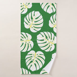 Seamless pattern of white monstera leaves on a dar bath towel