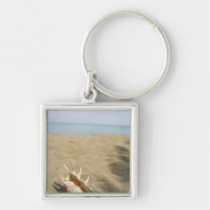 Seashell on sandy beach key ring