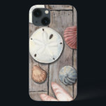 Seashore Treasures iPhone 13 Case<br><div class="desc">Megan Meagher is known for her simple art pieces. This image captures the simplicity of the seashore's treasures, including sand dollars and seashells in a pastel coloured tone. Meagher encompasses a wooden background in her image to contrast these treasures. Get this fine art print today on wood colour on your...</div>