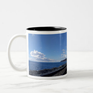 seaside and train track under blue sky Two-Tone coffee mug