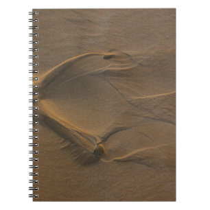 Selective focus photography of sand notebook