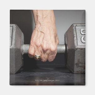 Senior woman lifting weights magnet