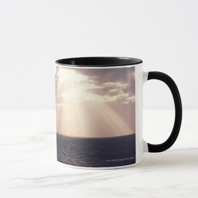 Setting sun shining through clouds over ocean mug (Right)