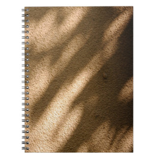 Shadow on brown carpeted floor notebook