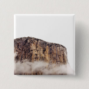 Sheer cliff rising above clouds 15 cm square badge