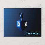 Shiny Blue Dreidel Postcard<br><div class="desc">A modernistic,  metallic blue dreidel against a dark,  night-like background.  Two of the Hebrew letters found on a dreidel,  nun and shin,  glow brightly.  Hebrew text reading "Chag Chanukkah Sameach" (Happy Hanukkah) also appears in glowing blue and white.</div>