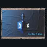 Shiny Blue Dreidel Throw Blanket<br><div class="desc">A modernistic,  metallic blue dreidel against a dark,  night-like background.  Two of the Hebrew letters found on a dreidel,  nun and shin,  glow brightly.  Add your own text.</div>