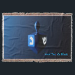 Shiny Blue Dreidel Throw Blanket<br><div class="desc">A modernistic,  metallic blue dreidel against a dark,  night-like background.  Two of the Hebrew letters found on a dreidel,  nun and shin,  glow brightly.  Add your own text.</div>