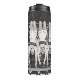 Showgirls on monkey bars, playful design. thermal tumbler