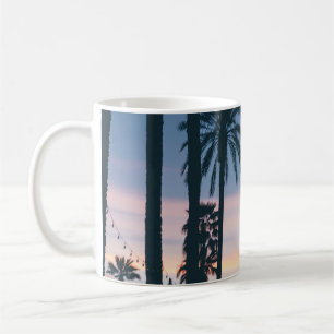 Silhouette of houses beside palm trees and pathway coffee mug