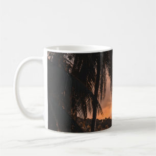 Silhouette of palm tree during golden hour coffee mug