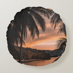 Silhouette of palm tree during golden hour round cushion