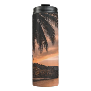 Silhouette of palm tree during golden hour thermal tumbler