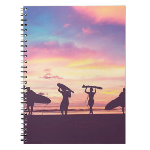 Silhouette Of surfer people carrying their surfboa Notebook