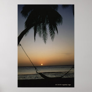 Silhuetted empty hammock at sunset poster