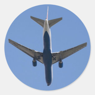 Single aeroplane on the blue sky background classic round sticker