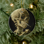 Skeleton with Burning Cigarette | Vincent van Gogh Ceramic Ornament<br><div class="desc">Skull of a Skeleton with Burning Cigarette (1886) by Vincent van Gogh is a striking and unconventional still-life painting that features a human skull with a lit cigarette between its teeth. The dark background enhances the starkness of the skeletal figure, while the small plume of smoke adds a sense of...</div>