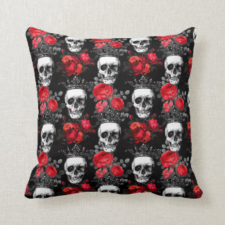 Skulls crowns and faded red roses on a dark black cushion