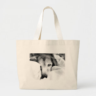 sleepy cuddle dog on bed black white grey large tote bag