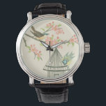 Small Birds Perched on a Branch and on a Birdcage Watch<br><div class="desc">Nancy Slocum's have painted many birds throughout the years. This image portrays two small blue and yellow birds perched on a branch surrounded by pink flowers and looking curious about a birdcage. Get this cool bird-themed art piece on your Zazzle product today.</div>