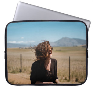 Smiling woman on brown and green field laptop sleeve