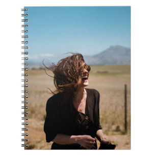 Smiling woman on brown and green field notebook
