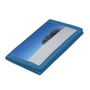 Snow covered field under a blue sky trifold wallet