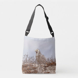 Snowy owl sitting on the beach crossbody bag