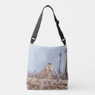 Snowy owl sitting on the beach crossbody bag