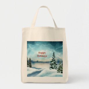 Snowy pine trees near a lake        tote bag