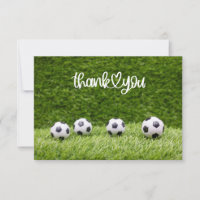 Soccer balls are on green grass