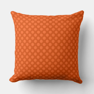 Solid orange polka dots on an orange background cushion