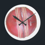 Spin Master's Sphere: A Fun Left Spin Cricket Ball Round Clock<br><div class="desc">"Spin Master's Sphere" – A Fun Left Spin Cricket Ball Design This "Spin Master's Sphere" design showcases the iconic red cricket ball, the very instrument wielded by skilled left-arm spin bowlers to weave their magical spells on the pitch. The close-up view highlights the worn texture and crucial stitching that allows...</div>