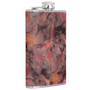 Stains in red hues on black grey grainy background hip flask