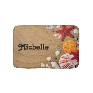 Starfish and seashells on brown beach sand bath mat