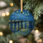 Starry Night Over the Rhône | Vincent van Gogh Ceramic Ornament<br><div class="desc">Starry Night Over the Rhône (1888) by Vincent van Gogh is a mesmerising Post-Impressionist painting that captures a serene nighttime view of the Rhône River in Arles, France. The artwork features a deep blue sky adorned with shimmering golden stars and their reflections on the water. In the foreground, two figures...</div>