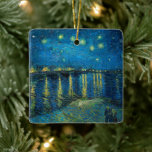 Starry Night Over the Rhône | Vincent van Gogh Ceramic Ornament<br><div class="desc">Starry Night Over the Rhône (1888) by Vincent van Gogh is a mesmerising Post-Impressionist painting that captures a serene nighttime view of the Rhône River in Arles, France. The artwork features a deep blue sky adorned with shimmering golden stars and their reflections on the water. In the foreground, two figures...</div>