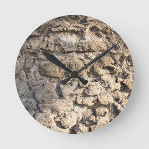 Stone wall of the large rough stones gray round clock