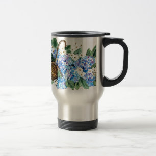 Straw basket with blue hydrangeas and white little travel mug