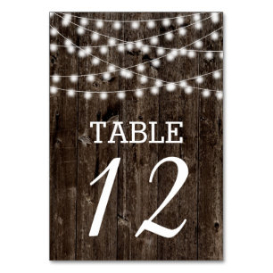 String of lights on old wood wedding table number