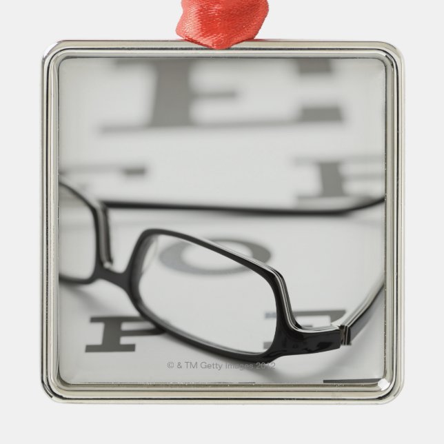 Studio shot of eyeglasses on eye chart metal tree decoration (Front)