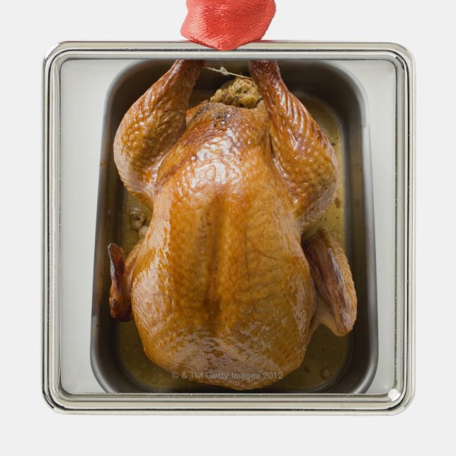 Stuffed roast turkey in roasting tray, close up metal ornament (Front)