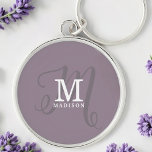 Stylish Calligraphy Monogram and Name Purple Key Ring<br><div class="desc">A beautiful feminine keychain with an elegant stylish name and monogram with classic serifs and a more ornate script calligraphy in a balanced and beautiful layout. The three elements blend together with a sophisticated harmony and create your own personal branding logo. Shown here with a trendy dusty purple background with...</div>