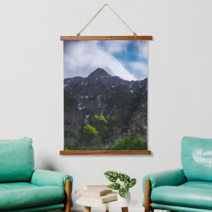 Sun lit green forest beneath the mountains hanging tapestry