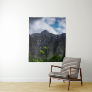 Sun lit green forest beneath the mountains tapestry