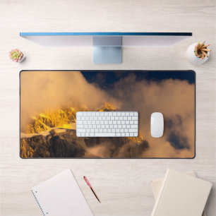 Sun lit mountains covered by clouds desk mat
