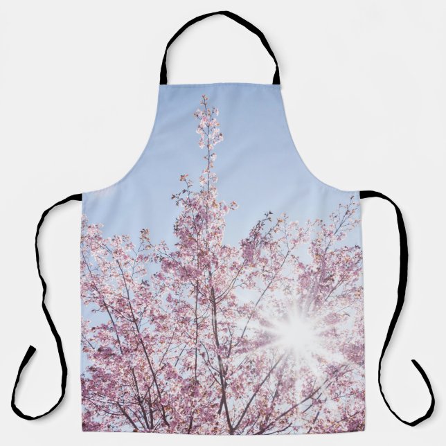 sun rays pass through pink flowers of a wow tree apron (Front)