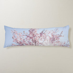 sun rays pass through pink flowers of a wow tree body cushion