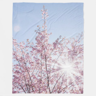sun rays pass through pink flowers of a wow tree fleece blanket