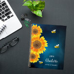 Sunflowers yellow bees blue sky name  planner<br><div class="desc">Get ready to organise your days with a touch of natural charm with our Personalised Sunflower and Bee Spiral Planner. This delightful planner features a serene dark blue sky background adorned with vibrant watercolored sunflowers and cheerful smiling bees, bringing a sense of joy and whimsy to your daily planning. Serene...</div>